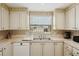 Well-lit kitchen featuring white cabinets, countertops, appliances, and a window at 313 Mariner Dr, North Port, FL 34287