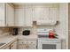 Kitchen with white cabinets, countertops, appliances, and stylish wallpaper accents at 313 Mariner Dr, North Port, FL 34287