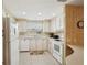Bright kitchen with white cabinetry, countertops, appliances, and a convenient breakfast bar at 313 Mariner Dr, North Port, FL 34287