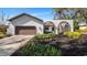 White stucco home with brown garage door and arched entryway at 4907 Parson Brown Ln, Palm Harbor, FL 34684