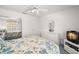Bright bedroom with a blue and yellow floral bedspread, white furniture, and a ceiling fan at 6594 Fairway Gardens Dr # 6594, Bradenton, FL 34203