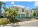Charming two-story home with a teal trim, and well-manicured lawn and mature palm trees at 6594 Fairway Gardens Dr # 6594, Bradenton, FL 34203
