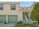 Charming two-story townhouse featuring a teal garage door and front doors, with manicured landscaping at 6594 Fairway Gardens Dr # 6594, Bradenton, FL 34203