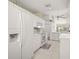 Open kitchen with white appliances, white cabinets, and tile floor at 6594 Fairway Gardens Dr # 6594, Bradenton, FL 34203
