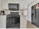 Close-up of the kitchen with white cabinets and black appliances at 13107 Texel Ave, New Port Richey, FL 34654