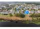 An aerial view of a large neighborhood with blue tarps on several roofs, showcasing the community layout and proximity to a body of water at 16605 Myrtle Sand Dr, Wimauma, FL 33598