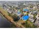 An aerial view of a large neighborhood with blue tarps on several roofs, showcasing the community layout and proximity to a body of water at 16605 Myrtle Sand Dr, Wimauma, FL 33598