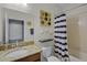 Bathroom featuring a granite countertop, tiled floors, shower, and decorative lighting at 16605 Myrtle Sand Dr, Wimauma, FL 33598