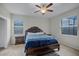 Bedroom with a ceiling fan, two windows, a queen-size bed, and two bedside tables at 16605 Myrtle Sand Dr, Wimauma, FL 33598