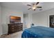 Bedroom with a ceiling fan, view of a TV, a queen-size bed, and carpet floors at 16605 Myrtle Sand Dr, Wimauma, FL 33598