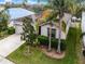 Beautiful home with lush landscaping, palm trees, and a well-manicured lawn at 16605 Myrtle Sand Dr, Wimauma, FL 33598