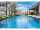 Sparkling in-ground pool inside screened enclosure, with patio area and lush landscaping at 16605 Myrtle Sand Dr, Wimauma, FL 33598