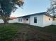 Exterior view of the backyard featuring a covered patio with fan, new grass and black trimmed windows at 302 E Clay Ave, Brandon, FL 33510