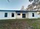 Exterior view of the backyard featuring a covered patio with fan, new grass and black trimmed windows at 302 E Clay Ave, Brandon, FL 33510