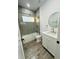 Modern bathroom features a walk-in shower, white vanity, and wood-look tile flooring at 302 E Clay Ave, Brandon, FL 33510