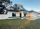 Charming single-story home with gray and white trim, a well-manicured lawn, and a white fence at 302 E Clay Ave, Brandon, FL 33510