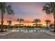 Resort-style community pool at dusk featuring private lounge areas and lush landscaping in a tropical setting at 5916 Jensen View Ave, Apollo Beach, FL 33572