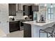 Modern kitchen island featuring stainless steel faucet, dark cabinets, and stainless oven hood at 5916 Jensen View Ave, Apollo Beach, FL 33572