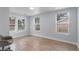 Well-lit bedroom featuring wood-look tile floors and multiple windows at 8514 N Mitchell Ave, Tampa, FL 33604