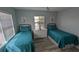 Bright guest bedroom with two twin beds, dresser, and window coverings at 721 Plumbrook Rd, Sun City Center, FL 33573
