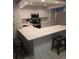 Updated kitchen with white cabinets, quartz counters, and breakfast bar at 721 Plumbrook Rd, Sun City Center, FL 33573