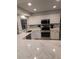 Updated kitchen with white cabinets, quartz counters, and breakfast bar at 721 Plumbrook Rd, Sun City Center, FL 33573