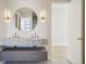 Elegant bathroom featuring a double vanity and a large, circular mirror at 1630 Douglas Ave, Dunedin, FL 34698