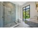 Contemporary bathroom with walk-in shower, marble vanity, and large window at 1630 Douglas Ave, Dunedin, FL 34698