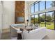 Bright living room with fireplace, high ceilings, and large windows offering backyard views at 1630 Douglas Ave, Dunedin, FL 34698