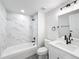 Clean bathroom with white vanity, marble tub surround, and grey floor at 206 S Water St, Plant City, FL 33563