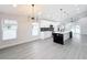 Modern kitchen with white cabinets, large island, and gray flooring at 206 S Water St, Plant City, FL 33563