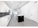 Modern kitchen with white cabinets, an island, and gray flooring at 206 S Water St, Plant City, FL 33563