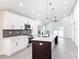 Open concept kitchen with white cabinets, stainless steel appliances, and a center island at 206 S Water St, Plant City, FL 33563