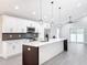 Modern kitchen with white cabinets, herringbone backsplash, and a large island at 206 S Water St, Plant City, FL 33563