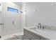 Bathroom with gray vanity, marble countertop, and a glass shower at 5032 W Longfellow Ave, Tampa, FL 33629
