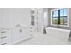 Spa-like bathroom with white cabinets, a soaking tub, and marble floors at 5032 W Longfellow Ave, Tampa, FL 33629