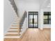 Light and airy entryway with a stunning staircase and modern double doors at 5032 W Longfellow Ave, Tampa, FL 33629