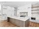 Modern kitchen with marble island, white cabinets, and herringbone backsplash at 5032 W Longfellow Ave, Tampa, FL 33629