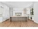 Modern kitchen with white cabinets, herringbone backsplash, large island, and hardwood floors at 5032 W Longfellow Ave, Tampa, FL 33629