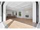 Open living room with kitchen and fireplace visible, hardwood floors, and high ceilings at 5032 W Longfellow Ave, Tampa, FL 33629