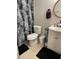 Bathroom featuring a sleek toilet, floating sink with vanity, and a stylish black and white shower curtain at 6010 Laketree Ln # L, Temple Terrace, FL 33617