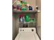 Laundry area featuring a white washing machine and dryer, shelves with detergent, and cleaning supplies at 6010 Laketree Ln # L, Temple Terrace, FL 33617