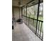 Screened in porch has tile floors, chair, and a view of the exterior yard at 6010 Laketree Ln # L, Temple Terrace, FL 33617