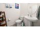 Small bathroom with pedestal sink, toilet, and decorative shelving at 14953 Flowing Gold Dr, Bradenton, FL 34212