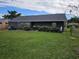 Expansive backyard with a well-maintained lawn and flowering bushes at 1006 39Th W Ave, Bradenton, FL 34205