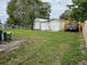 Large backyard with wooden fence and multiple storage sheds at 1006 39Th W Ave, Bradenton, FL 34205