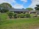 Ranch home with a lush green lawn and vibrant red flowers at 1006 39Th W Ave, Bradenton, FL 34205