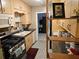 Galley kitchen with wood cabinets, gas range and microwave at 1006 39Th W Ave, Bradenton, FL 34205