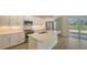 Open kitchen boasts white cabinets, stainless steel appliances, and an island with sink at 18265 Vizcaya Ct, Venice, FL 34293