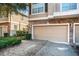 Tan garage door of a townhome with landscaping at 7001 Interbay Blvd # 336, Tampa, FL 33616